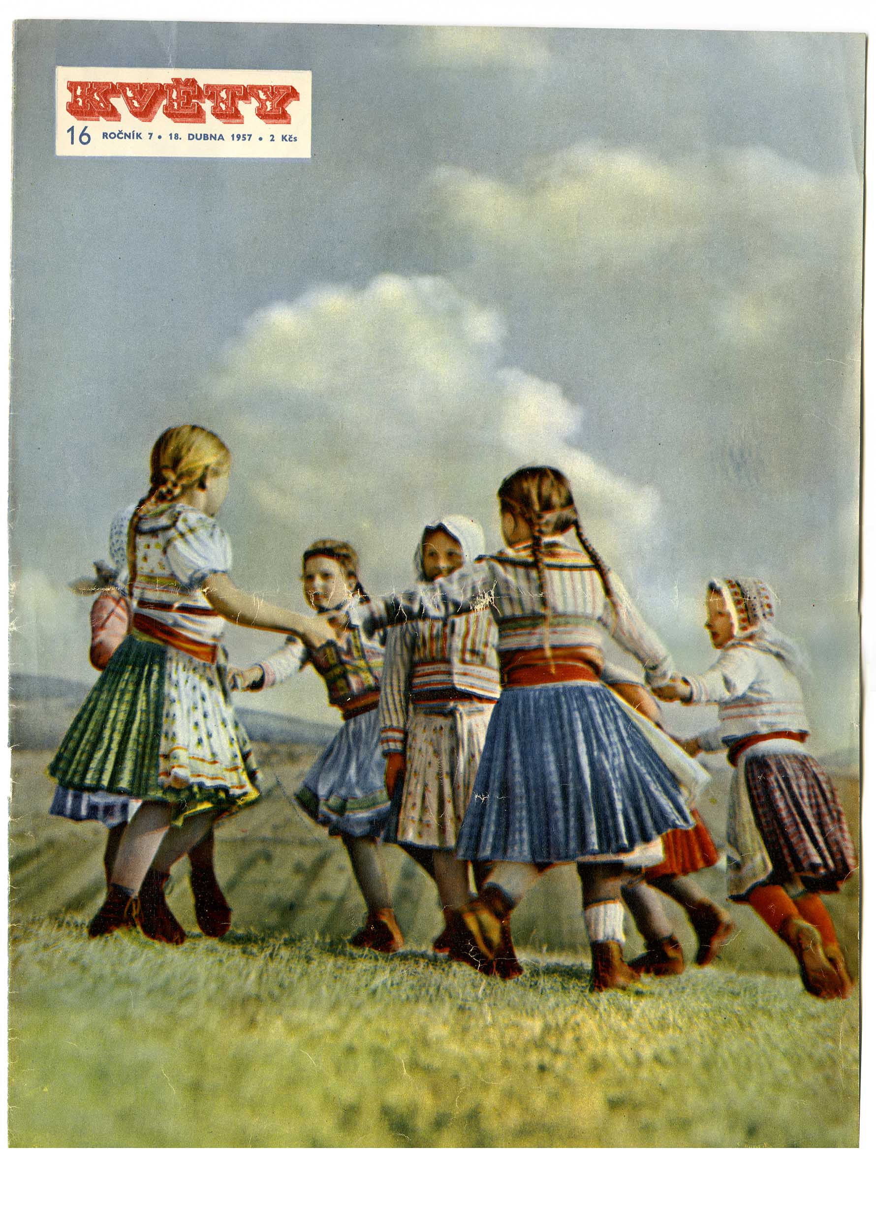 Tančící dívky v krojích na louce. 