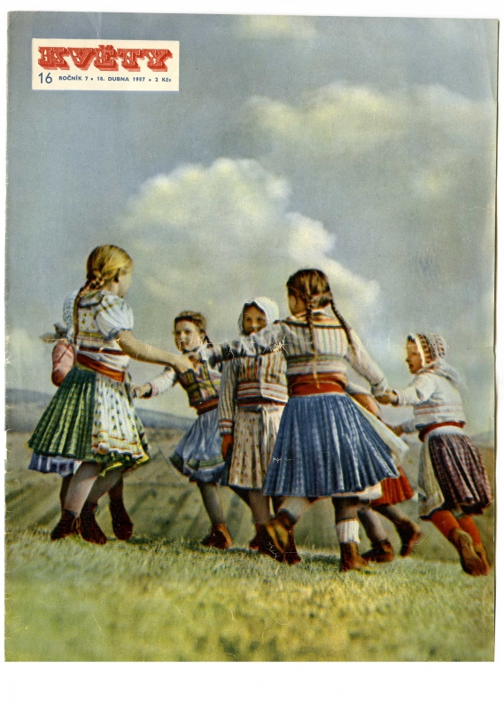 Tančící dívky v krojích na louce. 